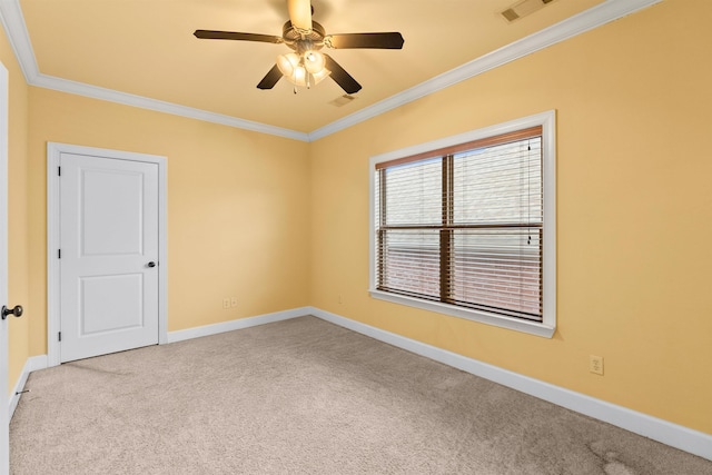 carpeted spare room with ceiling fan and ornamental molding