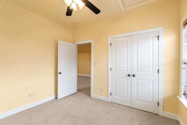 unfurnished bedroom featuring ceiling fan, light colored carpet, and a closet