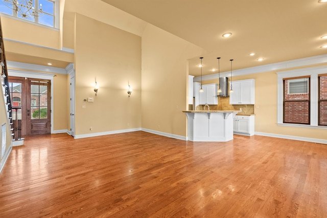 unfurnished living room featuring ornamental molding and light hardwood / wood-style floors