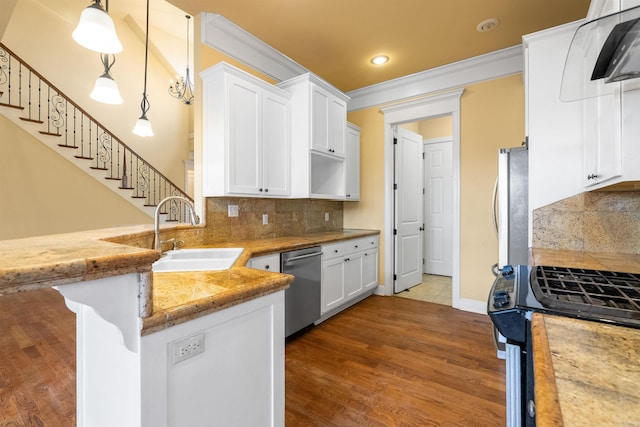 kitchen with white cabinets, appliances with stainless steel finishes, decorative light fixtures, sink, and kitchen peninsula