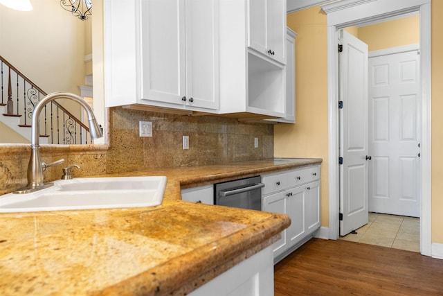 kitchen with decorative backsplash, sink, white cabinetry, and tile patterned flooring