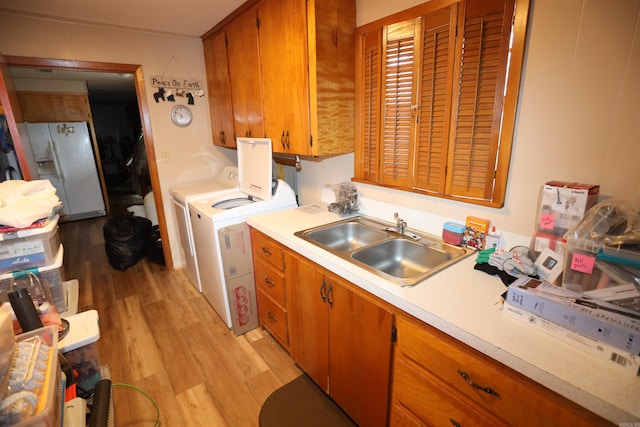 kitchen featuring sink, light hardwood / wood-style flooring, white refrigerator with ice dispenser, and washer and dryer