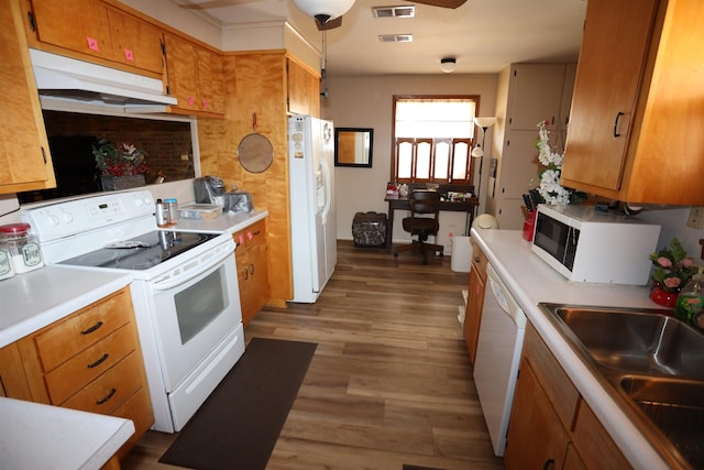 kitchen with sink, white appliances, dark wood-type flooring, and hanging light fixtures