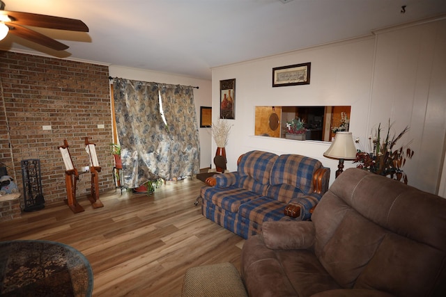 living room with ceiling fan, brick wall, hardwood / wood-style floors, and crown molding