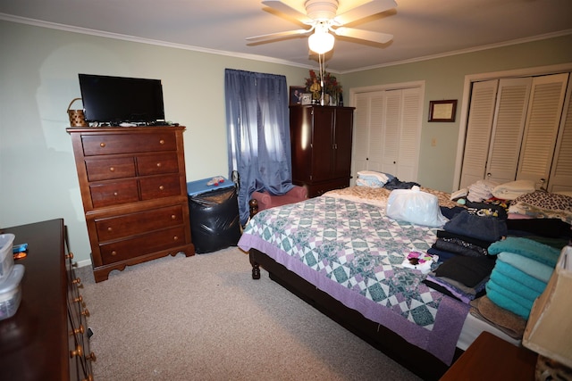 carpeted bedroom with ceiling fan, crown molding, and multiple closets