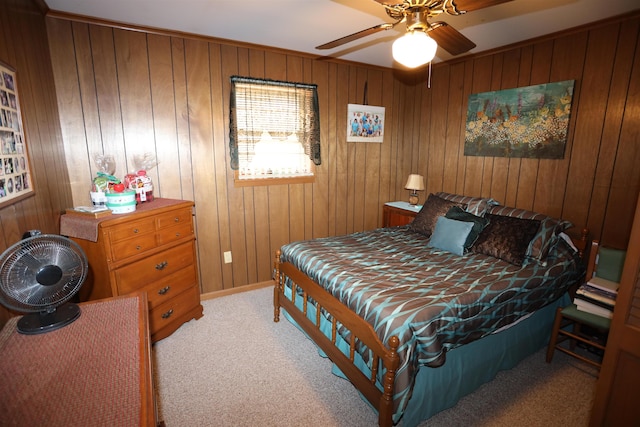 carpeted bedroom with ceiling fan and wood walls