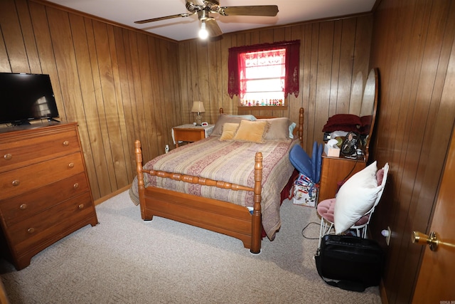 carpeted bedroom featuring ceiling fan and wood walls