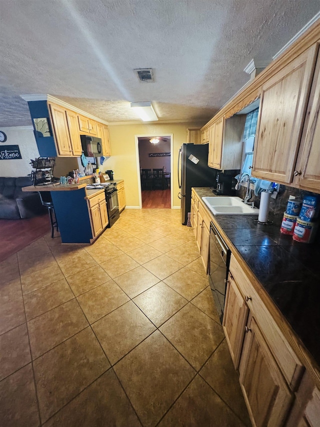 kitchen featuring light brown cabinetry, sink, a textured ceiling, light tile patterned floors, and black appliances