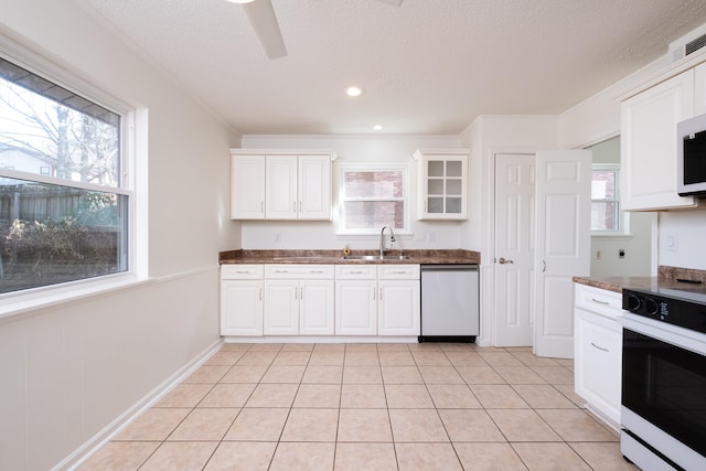 kitchen with stainless steel dishwasher, sink, white cabinetry, electric stove, and a textured ceiling