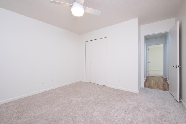 unfurnished bedroom with ceiling fan, a closet, and light carpet