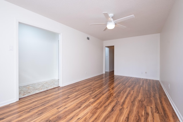 unfurnished room featuring ceiling fan, dark hardwood / wood-style floors, and a textured ceiling