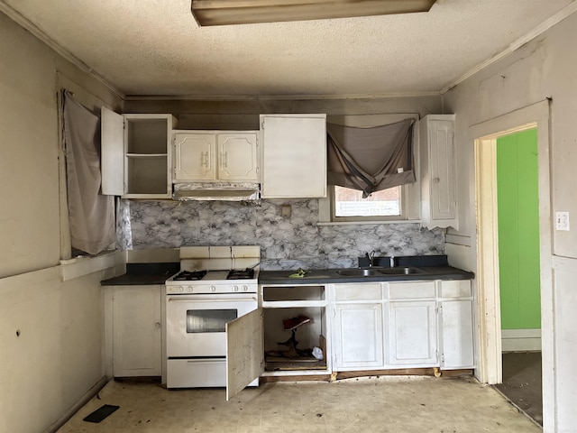 kitchen with dark countertops, white cabinets, a sink, white range with gas stovetop, and under cabinet range hood