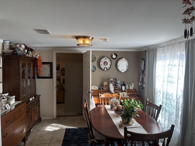 dining area featuring light tile patterned flooring and ornamental molding