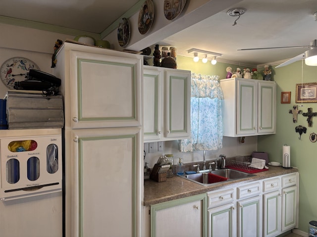 kitchen with sink, ceiling fan, white cabinetry, and ornamental molding