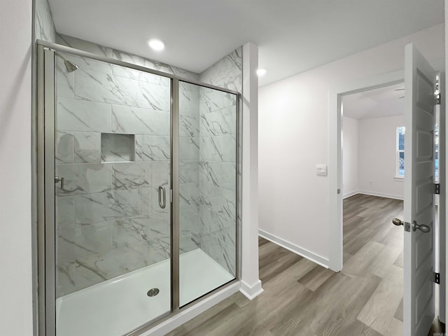 bathroom with wood-type flooring and an enclosed shower