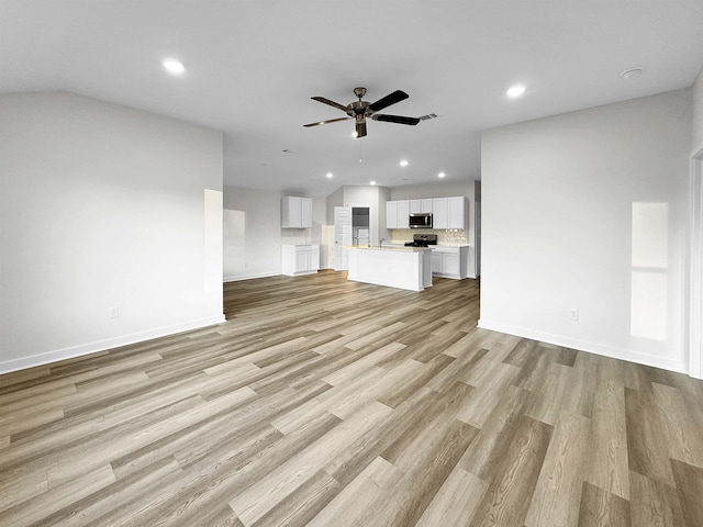 unfurnished living room with light wood-type flooring and ceiling fan