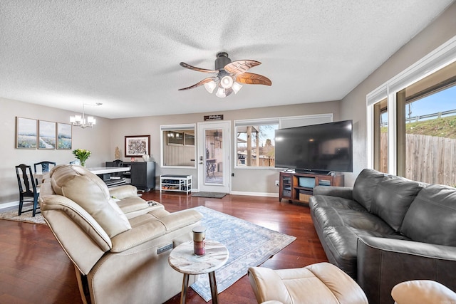 living room with a textured ceiling, dark wood-type flooring, and ceiling fan with notable chandelier