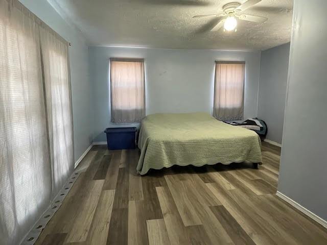 bedroom with a textured ceiling, dark hardwood / wood-style floors, and ceiling fan