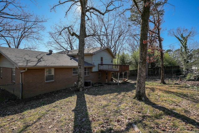 back of property with a deck, a lawn, and central AC