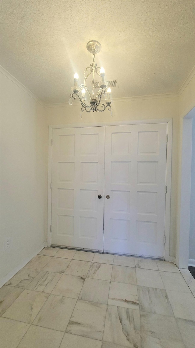 interior space featuring an inviting chandelier, a textured ceiling, and crown molding