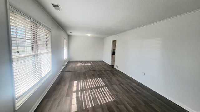 spare room featuring crown molding and dark hardwood / wood-style floors