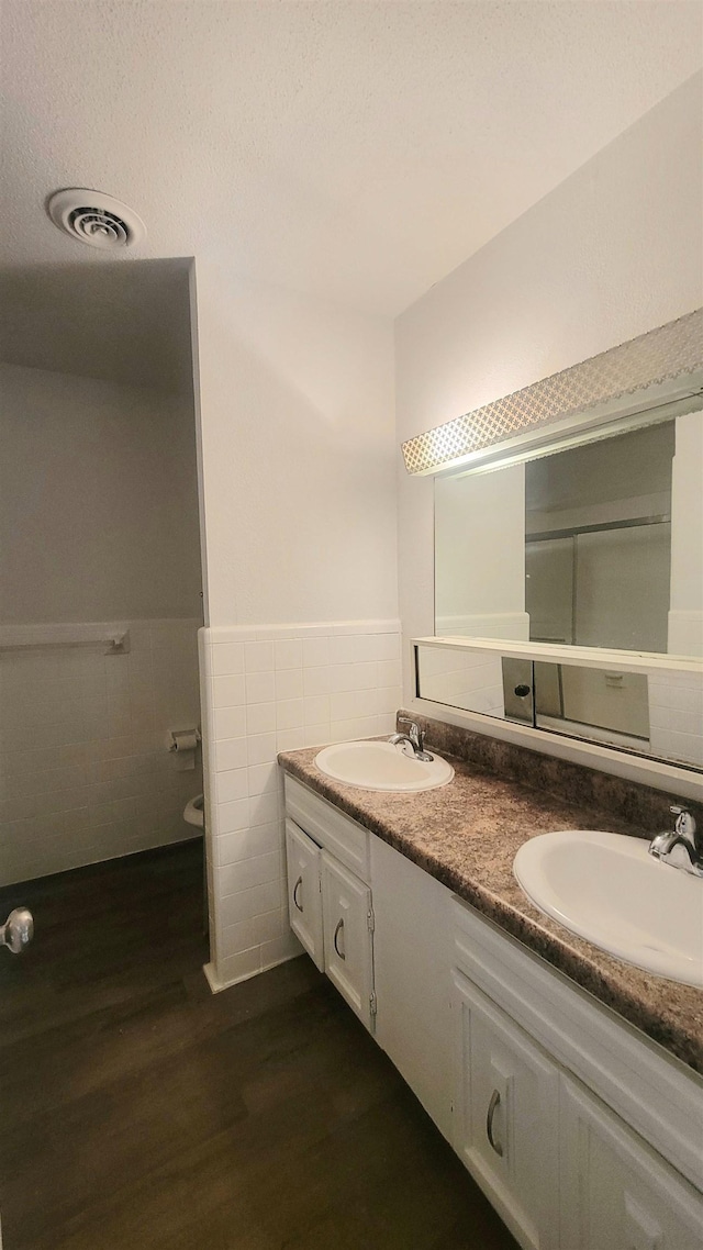 bathroom featuring vanity, hardwood / wood-style flooring, tile walls, and toilet