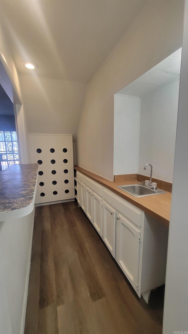 kitchen featuring sink, dark wood-type flooring, white cabinetry, and lofted ceiling