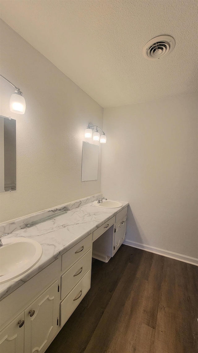 bathroom featuring hardwood / wood-style floors, a textured ceiling, and vanity