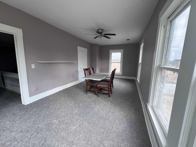 carpeted dining room with ceiling fan