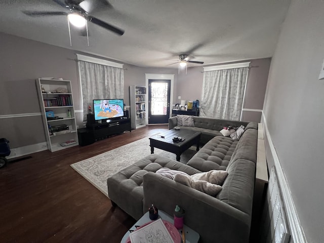 living room featuring ceiling fan, a textured ceiling, and dark hardwood / wood-style flooring