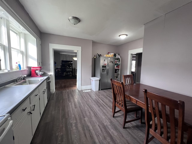 kitchen with sink, white cabinets, dark wood-type flooring, and appliances with stainless steel finishes