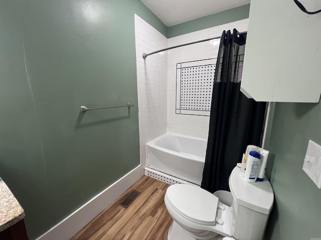 bathroom featuring hardwood / wood-style flooring, shower / tub combo, and toilet