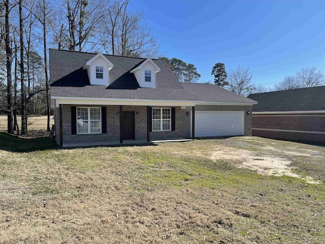 view of front of house with a garage, a front yard, and a porch