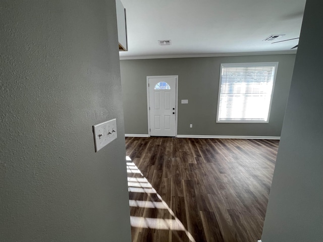 foyer entrance with crown molding and dark hardwood / wood-style floors