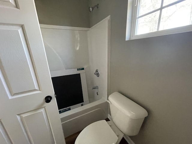 bathroom with washtub / shower combination and toilet