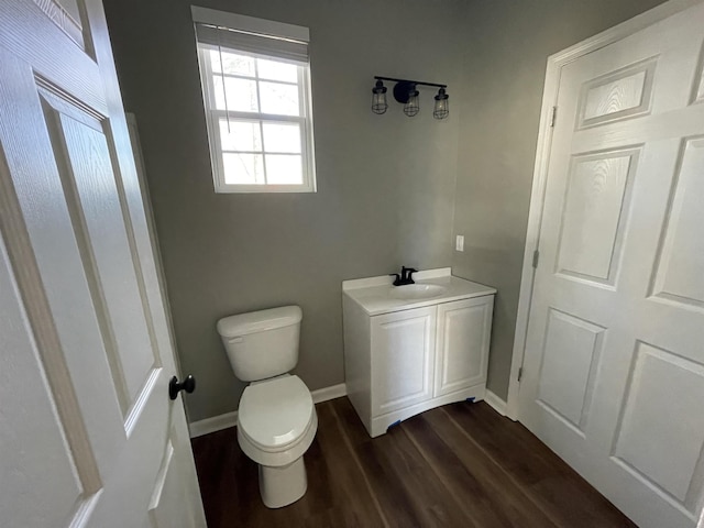 bathroom featuring wood-type flooring, toilet, and vanity