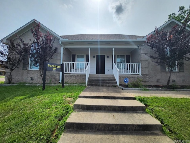 view of front of house featuring covered porch and a front lawn