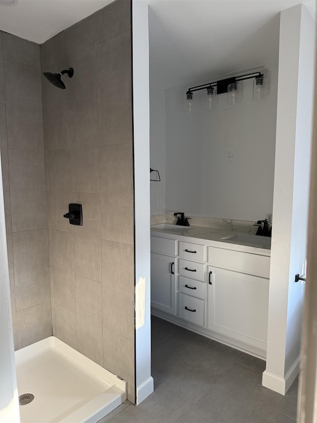 bathroom featuring tile patterned flooring, vanity, and tiled shower