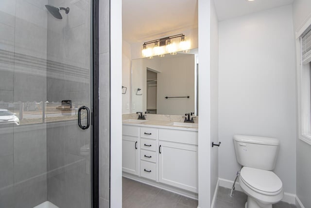 bathroom featuring tile patterned flooring, walk in shower, vanity, and toilet