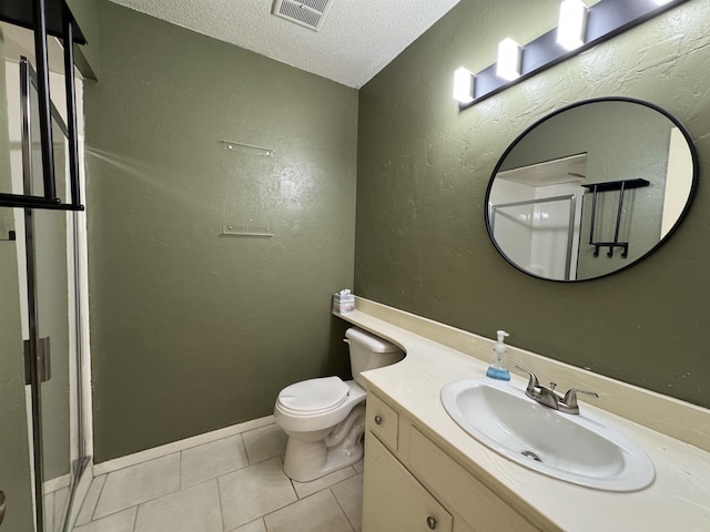 bathroom featuring a textured ceiling, tile patterned floors, a shower with door, vanity, and toilet