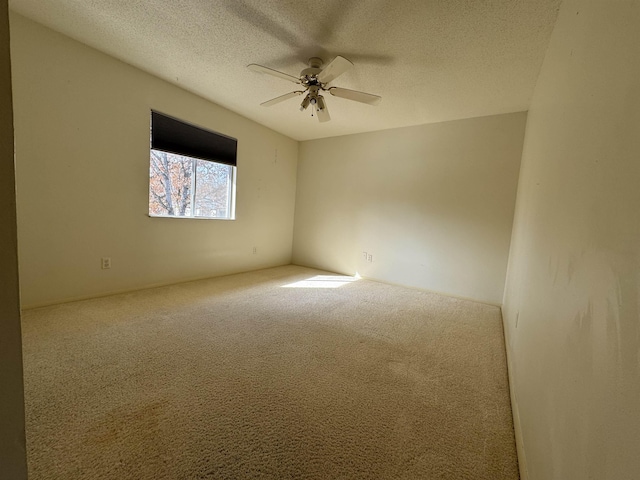 unfurnished room featuring ceiling fan, carpet, and a textured ceiling