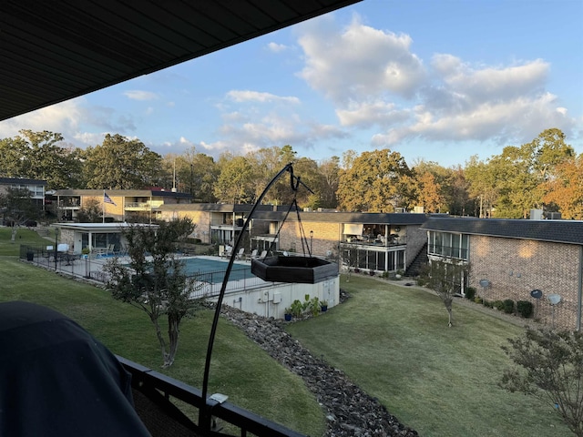 view of pool with grilling area and a yard