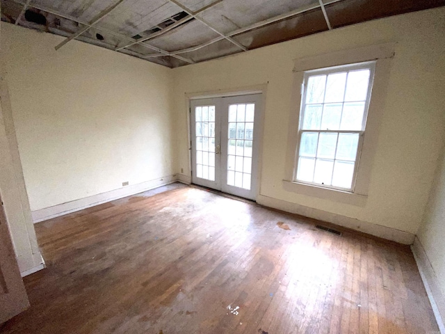 spare room featuring hardwood / wood-style flooring and french doors