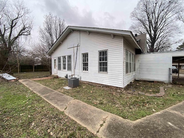 view of property exterior with cooling unit and a yard