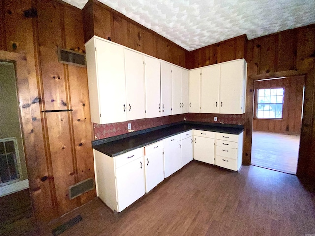 kitchen with white cabinets, a textured ceiling, and dark hardwood / wood-style flooring