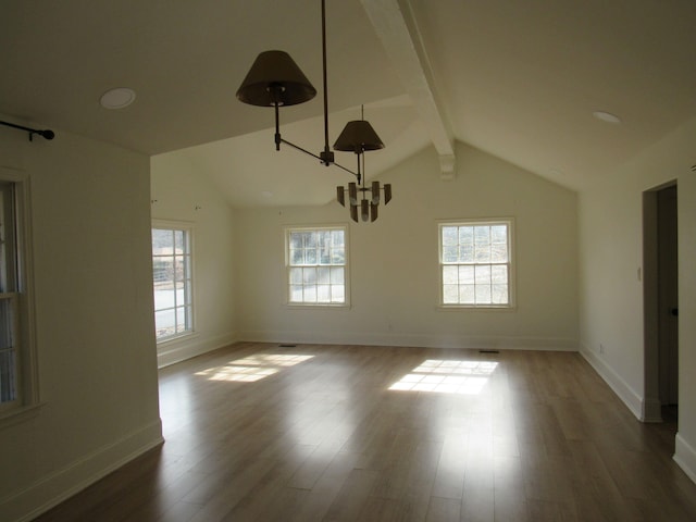 unfurnished room with lofted ceiling with beams, plenty of natural light, and dark wood-type flooring