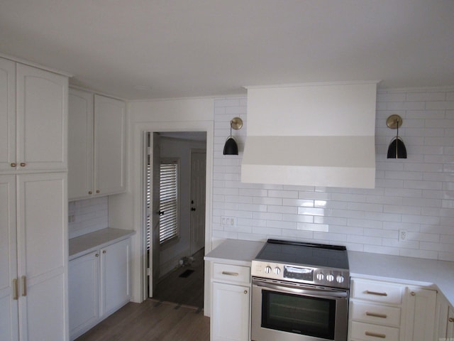 kitchen featuring white cabinetry, stainless steel electric range oven, dark hardwood / wood-style flooring, decorative backsplash, and exhaust hood