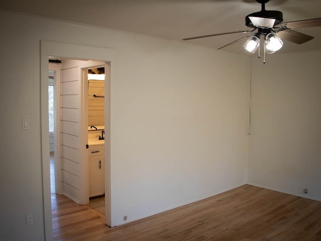 spare room featuring ceiling fan, ornamental molding, and light wood-type flooring