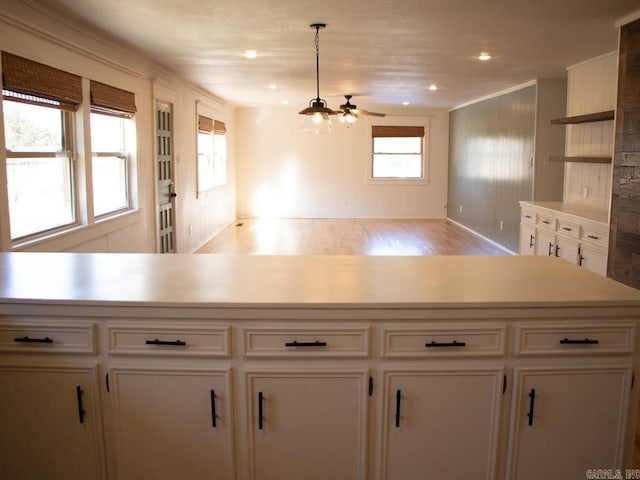 kitchen featuring decorative light fixtures, white cabinetry, and ceiling fan