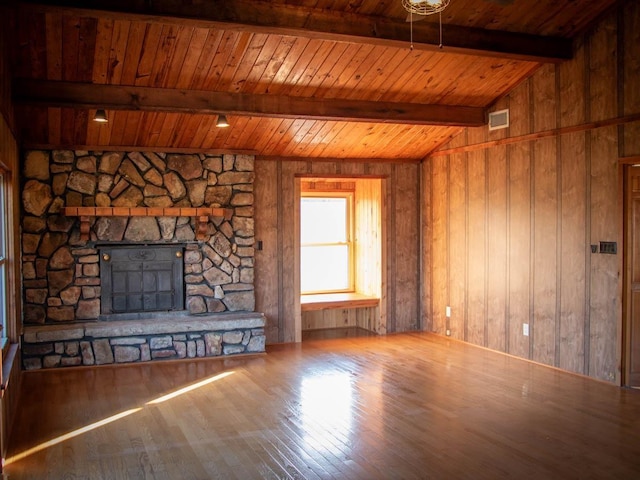 unfurnished living room featuring wooden ceiling, wood walls, hardwood / wood-style floors, and a fireplace